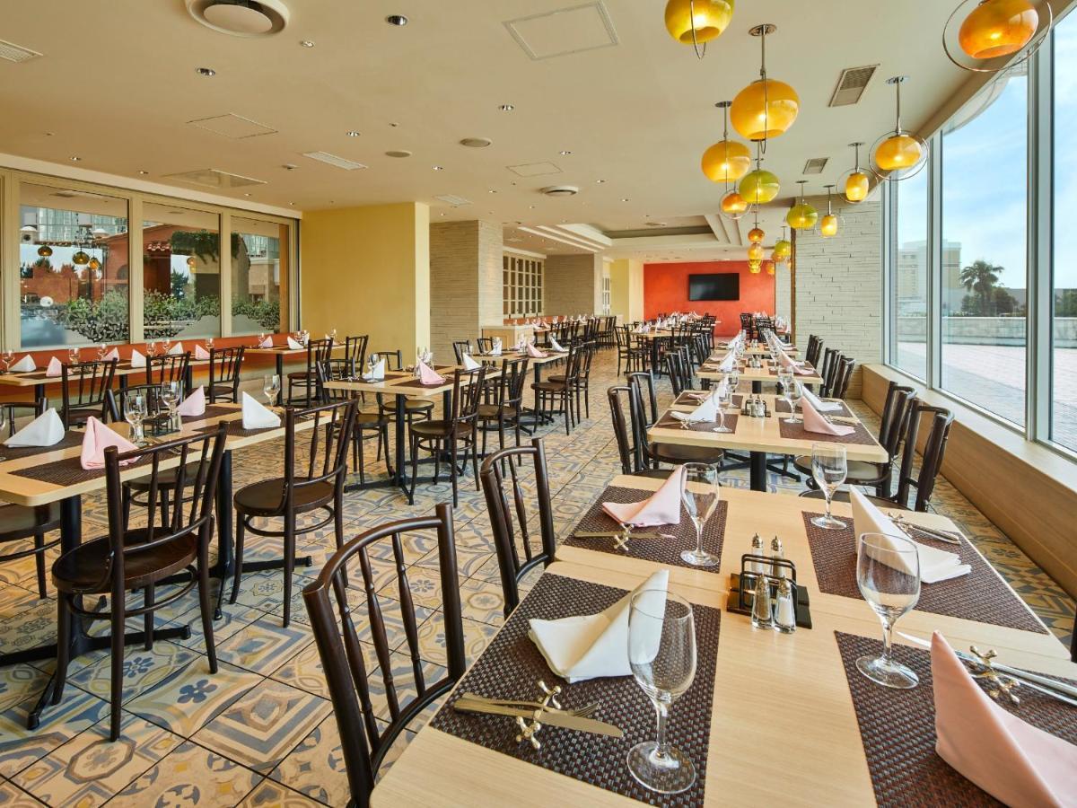 Grand Nikko Tokyo Bay Maihama Ξενοδοχείο Urayasu Εξωτερικό φωτογραφία The photo shows a spacious restaurant interior with multiple wooden tables arranged neatly. Each table is set with plates, glasses, and folded napkins, suggesting it's prepared for dining. The decor features large windows allowing natural light to fl