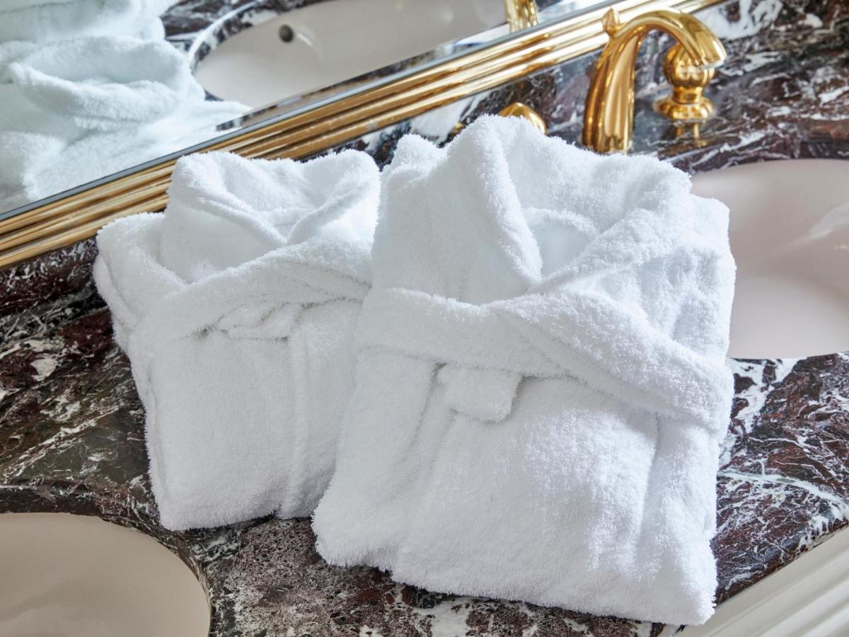 Grand Nikko Tokyo Bay Maihama Ξενοδοχείο Urayasu Εξωτερικό φωτογραφία The photo shows two white bathrobes neatly folded and placed on a marble surface, likely in a luxurious bathroom setting. The bathrobes have a simple, classic design with belts tied around them. In the background, there appears to be a decorative mir