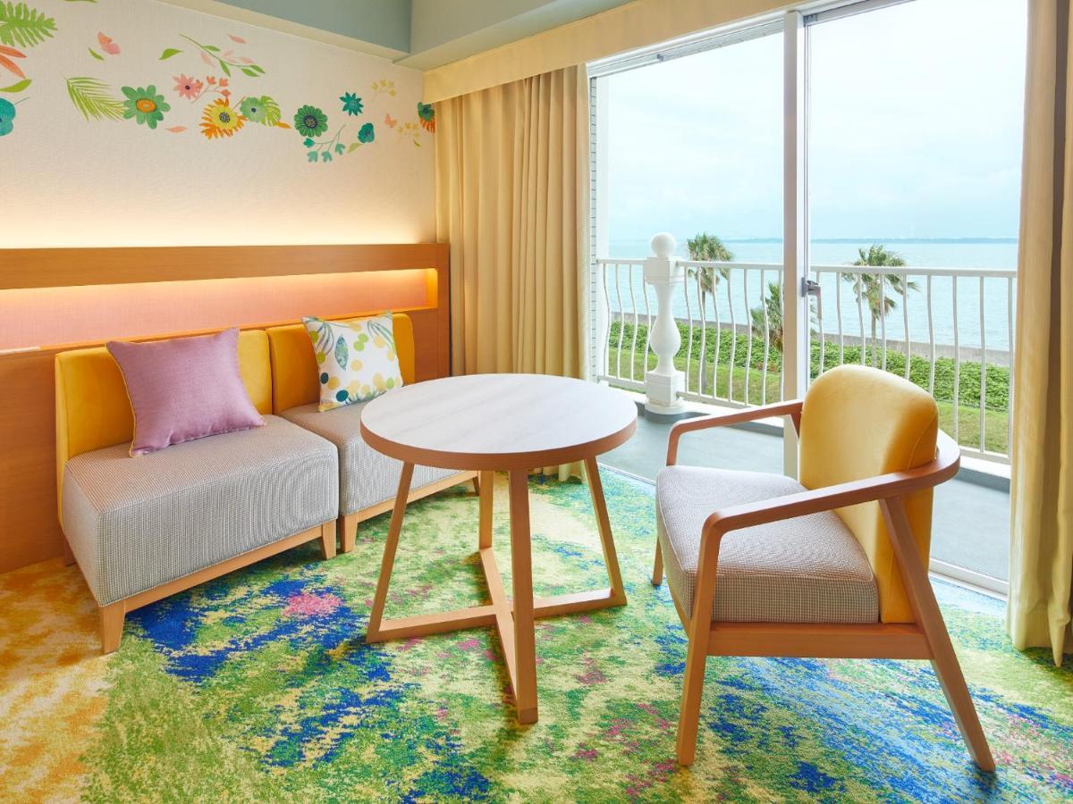 Grand Nikko Tokyo Bay Maihama Ξενοδοχείο Urayasu Εξωτερικό φωτογραφία The photo shows a cozy interior space, likely a hotel room or a lounge area. It features a small round table in the center surrounded by comfortable seating. There are two chairs: one is a light wooden frame with a yellow seat, and the other has a mo