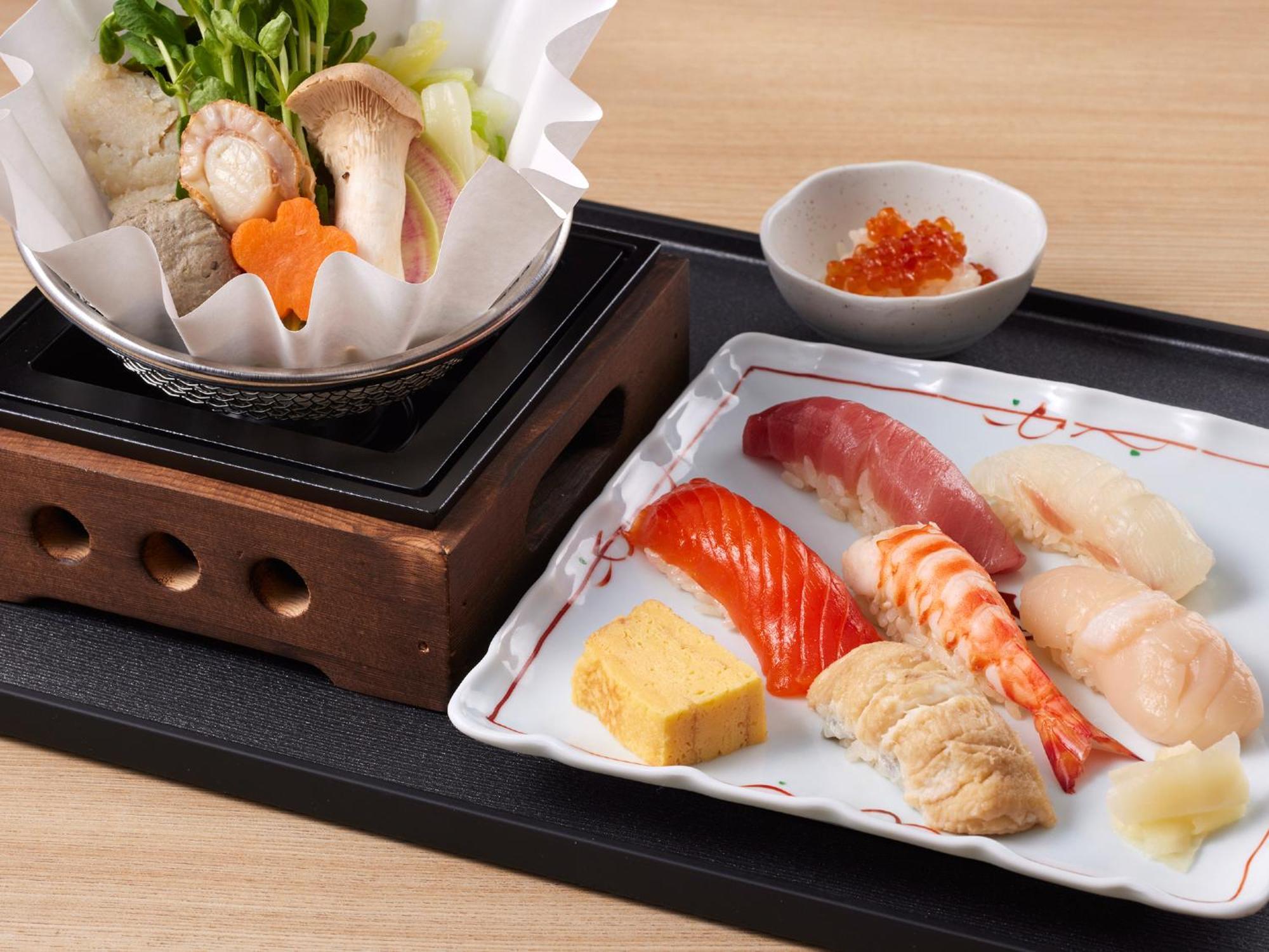 Grand Nikko Tokyo Bay Maihama Ξενοδοχείο Urayasu Εξωτερικό φωτογραφία The photo features a Japanese meal presented on a wooden tray. On the left, there is a small pot with a clear broth containing vegetables, mushrooms, and possibly meat, indicated by green herbs and a piece shaped like a flower. On the right, there is