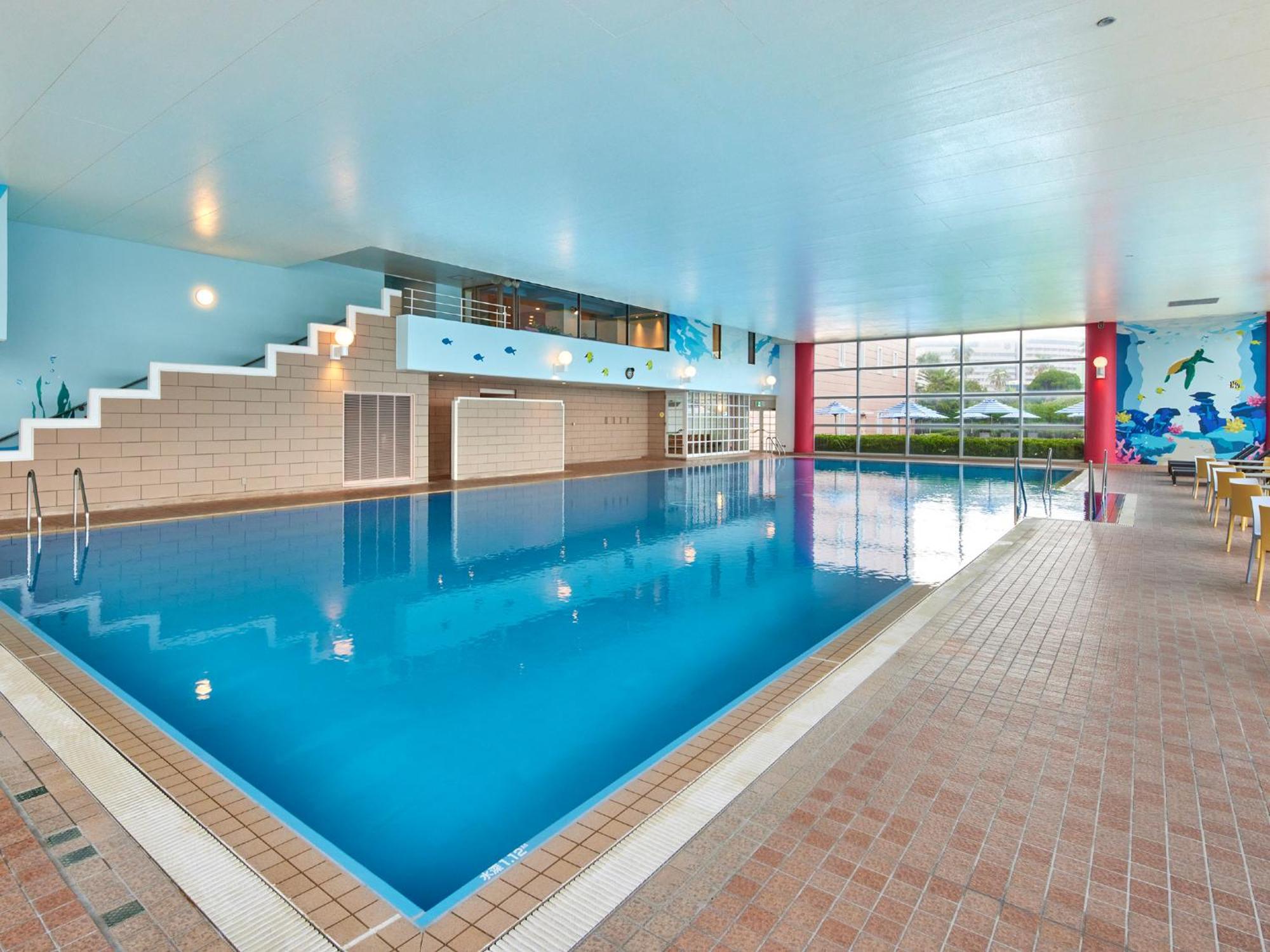 Grand Nikko Tokyo Bay Maihama Ξενοδοχείο Urayasu Εξωτερικό φωτογραφία The photo shows an indoor swimming pool area with a spacious design. The pool has a clear blue water surface and is surrounded by a tiled deck. On one side of the pool, there are steps leading into the water, and there are large windows letting in na