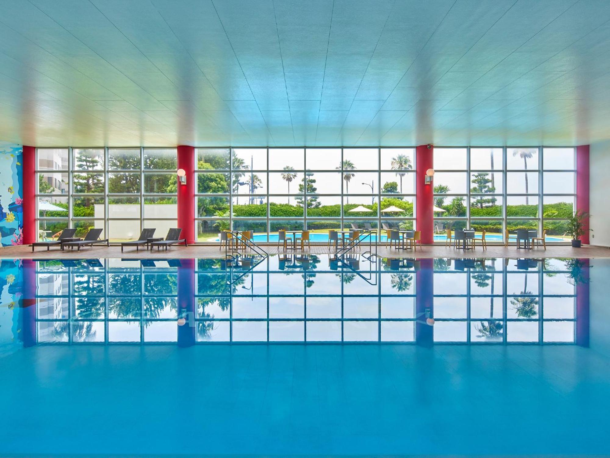 Grand Nikko Tokyo Bay Maihama Ξενοδοχείο Urayasu Εξωτερικό φωτογραφία The photo shows an indoor swimming pool with bright blue water. The pool area is spacious, characterized by large windows that allow natural light to flood in, creating a vibrant atmosphere. The walls are painted in a soft color, with accents of red.